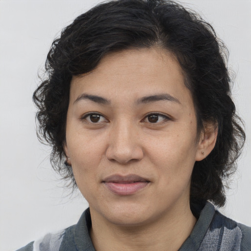 Joyful latino adult female with medium  brown hair and brown eyes