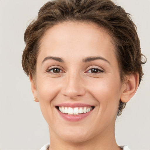 Joyful white young-adult female with short  brown hair and green eyes