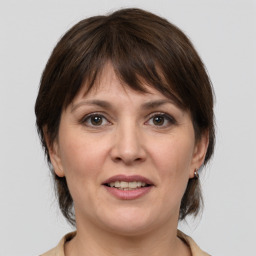 Joyful white adult female with medium  brown hair and grey eyes