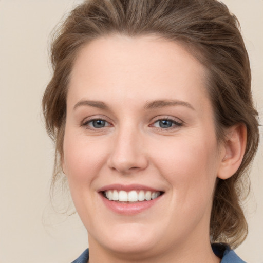 Joyful white young-adult female with medium  brown hair and blue eyes