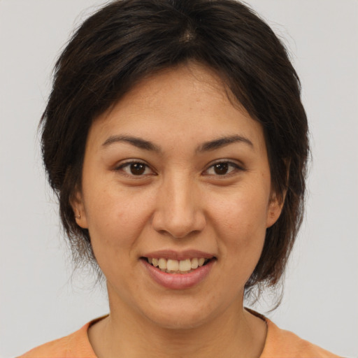 Joyful asian adult female with medium  brown hair and brown eyes