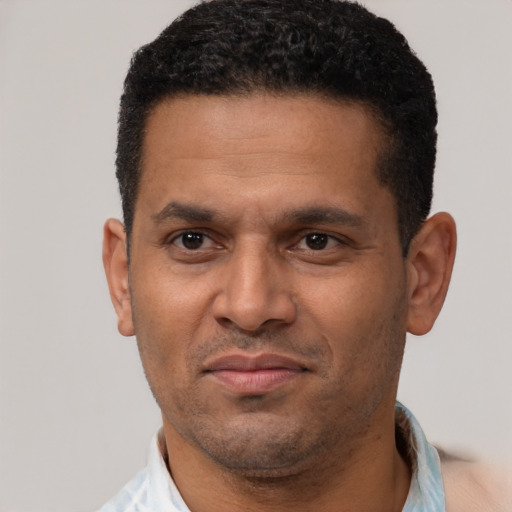 Joyful latino adult male with short  black hair and brown eyes