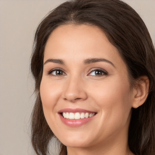 Joyful white young-adult female with long  brown hair and brown eyes