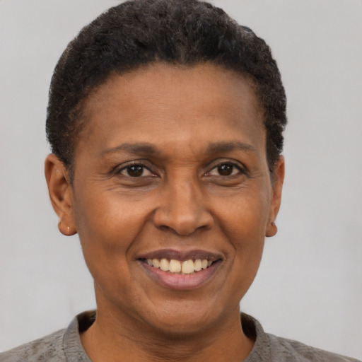 Joyful black adult female with short  brown hair and brown eyes