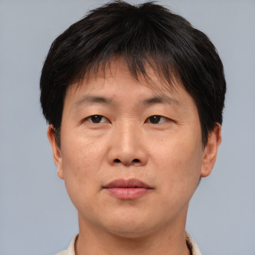 Joyful asian adult male with short  brown hair and brown eyes