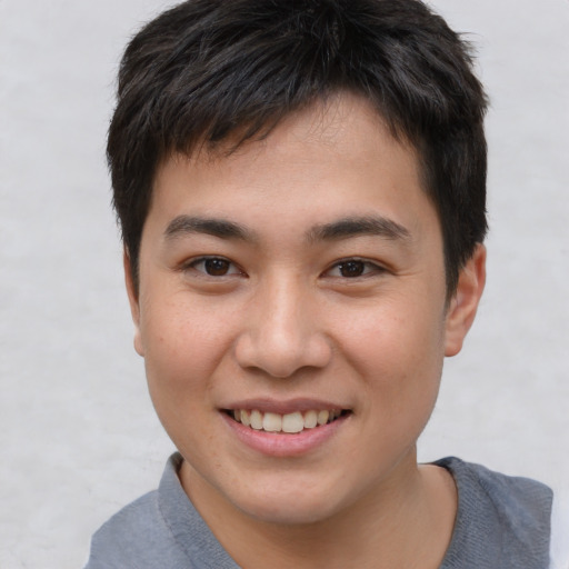 Joyful asian young-adult male with short  brown hair and brown eyes