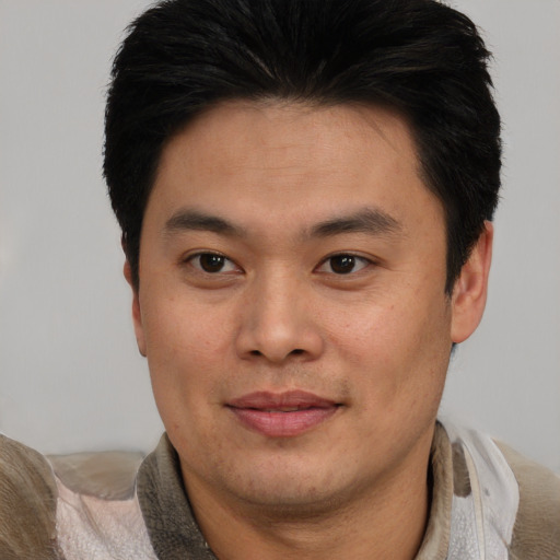 Joyful asian young-adult male with short  brown hair and brown eyes
