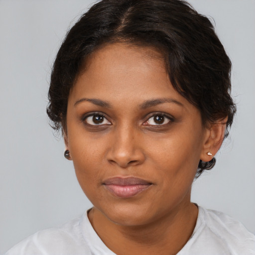 Joyful black young-adult female with medium  brown hair and brown eyes