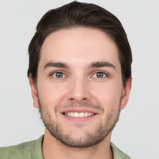 Joyful white young-adult male with short  brown hair and grey eyes