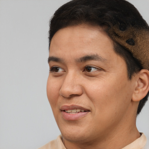 Joyful latino young-adult male with short  brown hair and brown eyes