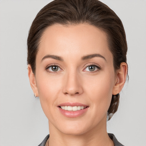 Joyful white young-adult female with medium  brown hair and grey eyes