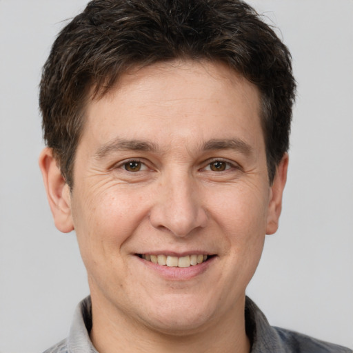 Joyful white adult male with short  brown hair and brown eyes