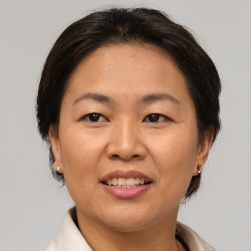 Joyful asian adult female with medium  brown hair and brown eyes