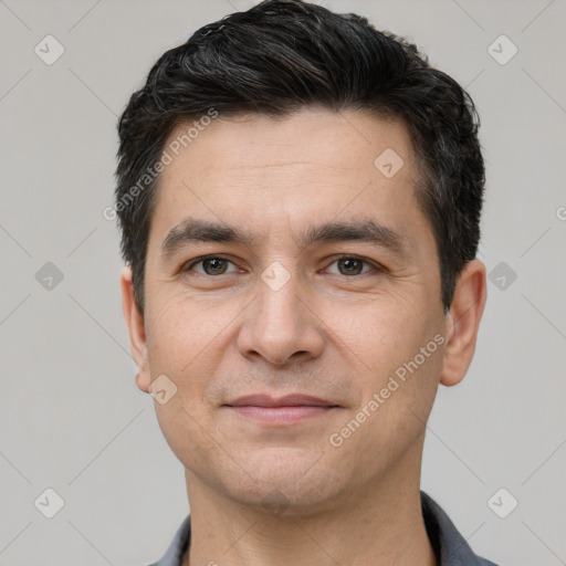 Joyful white adult male with short  black hair and brown eyes