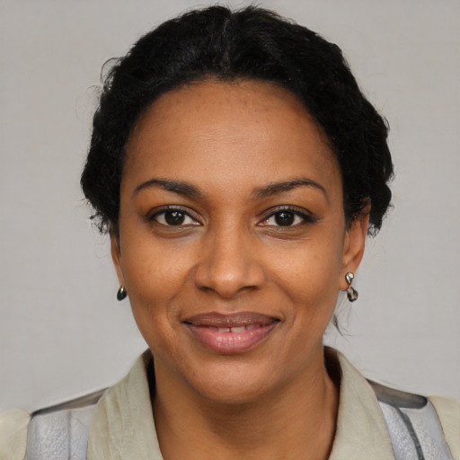 Joyful black young-adult female with short  black hair and brown eyes