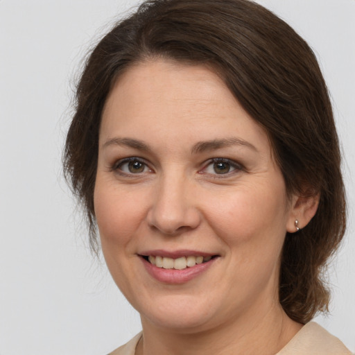 Joyful white adult female with medium  brown hair and brown eyes