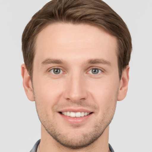 Joyful white young-adult male with short  brown hair and grey eyes