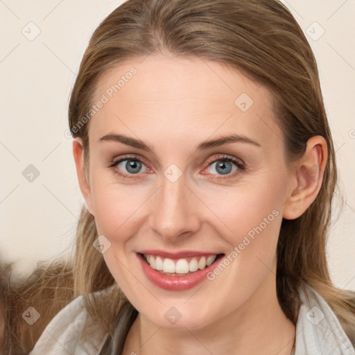 Joyful white young-adult female with long  brown hair and blue eyes