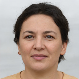 Joyful white adult female with medium  brown hair and brown eyes