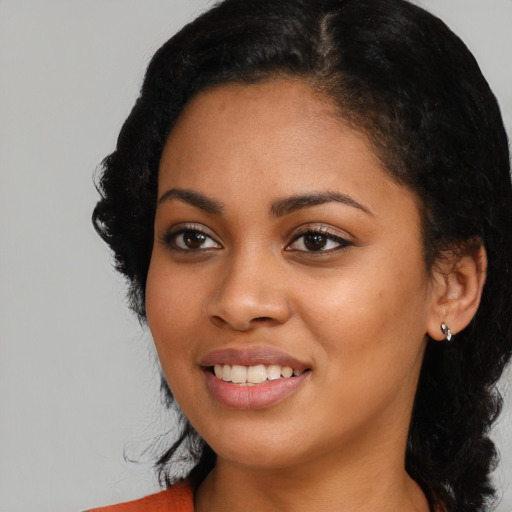 Joyful latino young-adult female with long  black hair and brown eyes