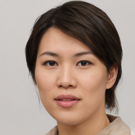Joyful asian young-adult female with medium  brown hair and brown eyes