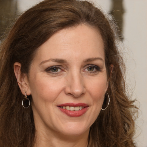 Joyful white adult female with long  brown hair and brown eyes