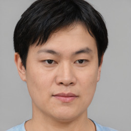 Joyful asian young-adult male with short  black hair and brown eyes