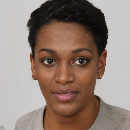 Joyful black young-adult female with short  black hair and brown eyes