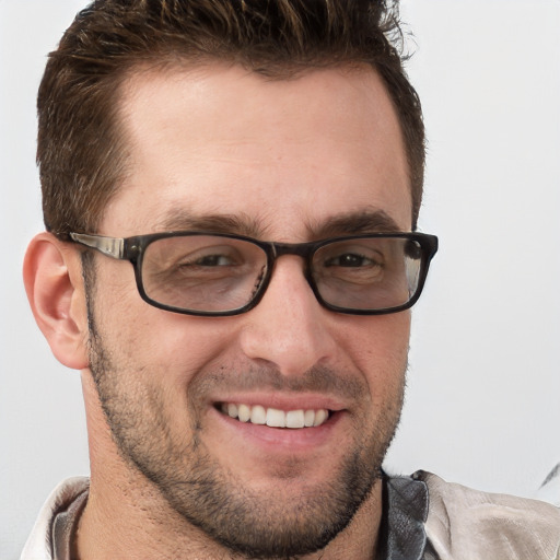 Joyful white adult male with short  brown hair and blue eyes