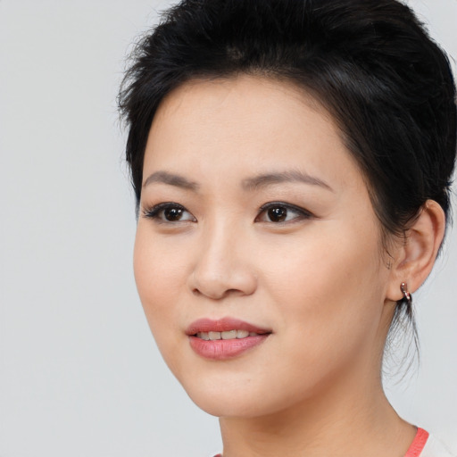 Joyful asian young-adult female with medium  black hair and brown eyes