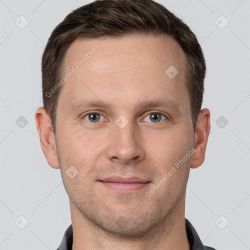 Joyful white young-adult male with short  brown hair and grey eyes