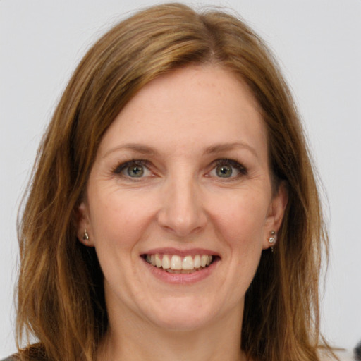 Joyful white young-adult female with long  brown hair and green eyes