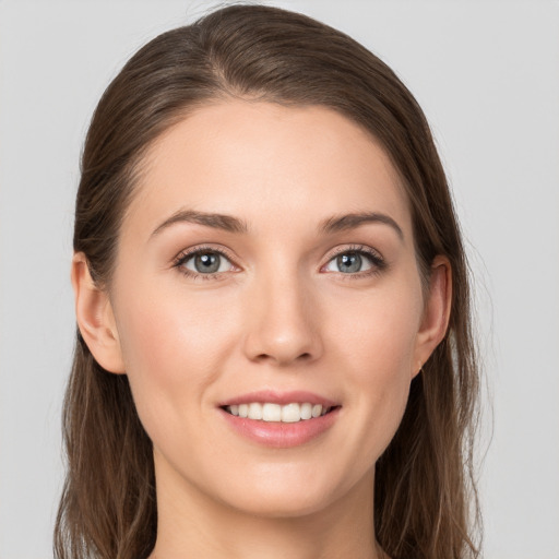 Joyful white young-adult female with long  brown hair and grey eyes