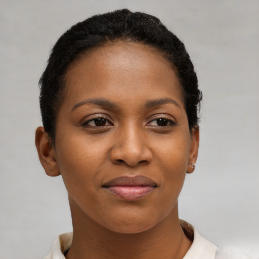 Joyful black young-adult female with short  brown hair and brown eyes