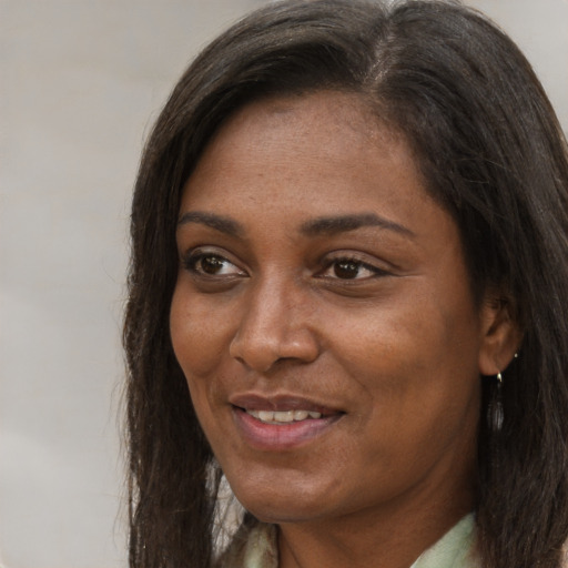 Joyful black adult female with long  brown hair and brown eyes