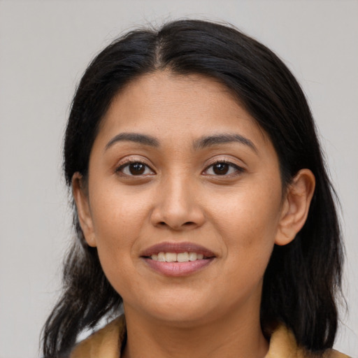 Joyful latino young-adult female with medium  brown hair and brown eyes
