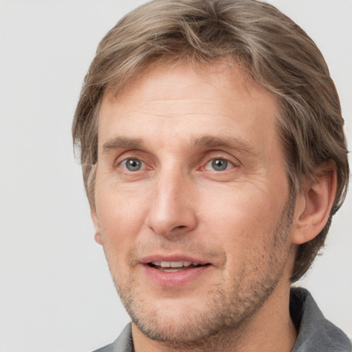 Joyful white adult male with short  brown hair and grey eyes