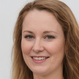 Joyful white young-adult female with long  brown hair and green eyes