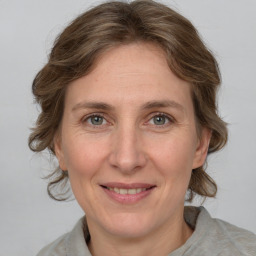 Joyful white adult female with medium  brown hair and grey eyes