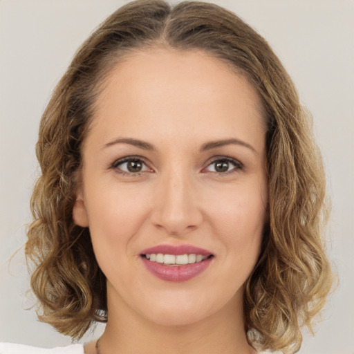 Joyful white young-adult female with medium  brown hair and green eyes