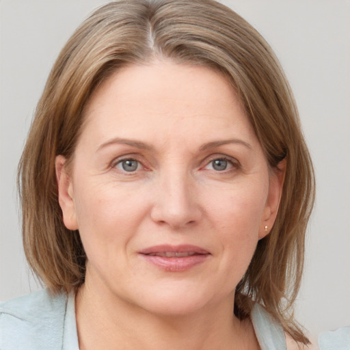 Joyful white adult female with medium  brown hair and grey eyes