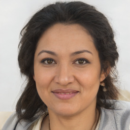 Joyful latino adult female with medium  brown hair and brown eyes