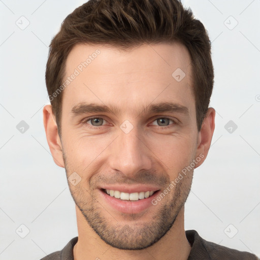 Joyful white young-adult male with short  brown hair and grey eyes