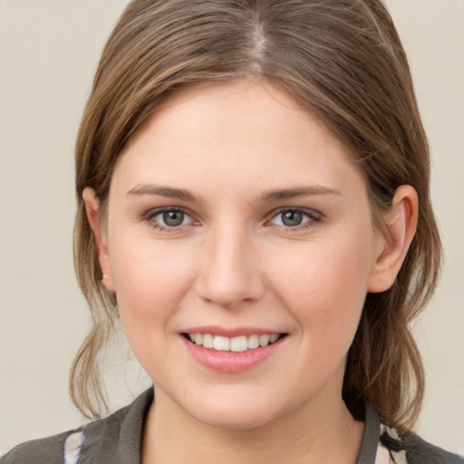 Joyful white young-adult female with medium  brown hair and grey eyes