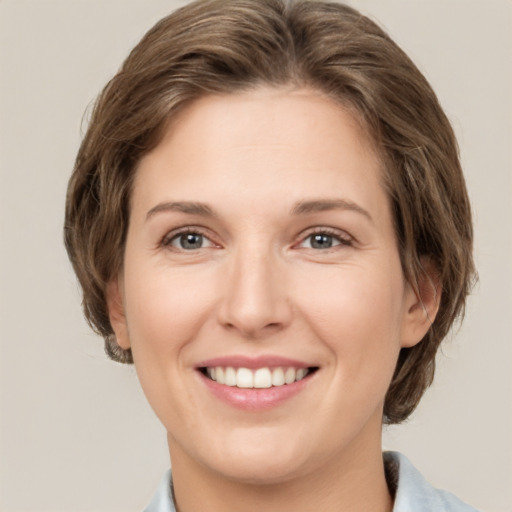 Joyful white young-adult female with medium  brown hair and grey eyes