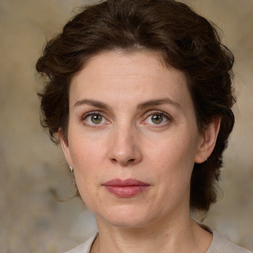 Joyful white adult female with medium  brown hair and green eyes