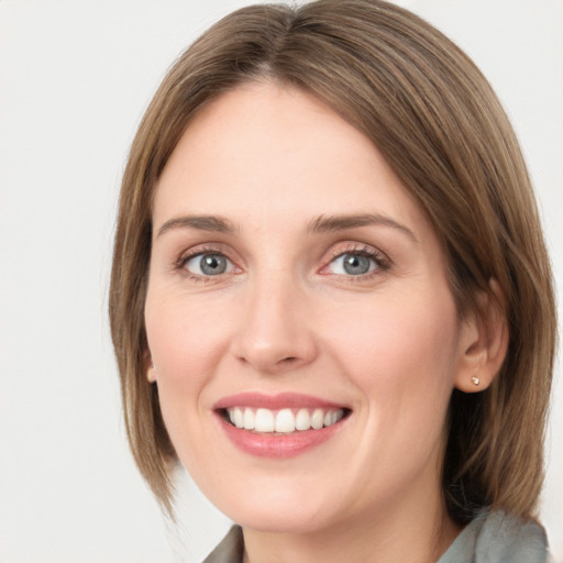 Joyful white young-adult female with medium  brown hair and green eyes