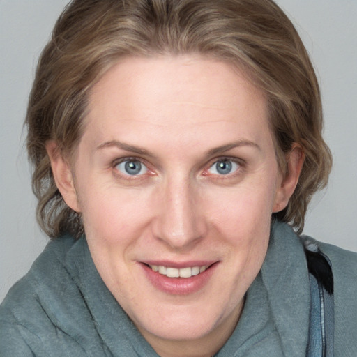 Joyful white adult female with medium  brown hair and blue eyes