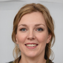 Joyful white young-adult female with medium  brown hair and blue eyes