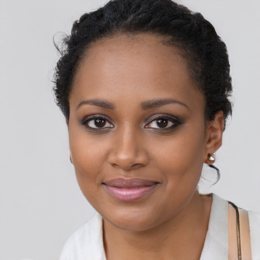 Joyful black young-adult female with short  brown hair and brown eyes